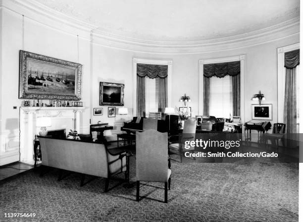 Seating, a Steinway grand piano, and several paintings in President Harry S Truman's second-floor Oval Room study, the White House, Washington,...