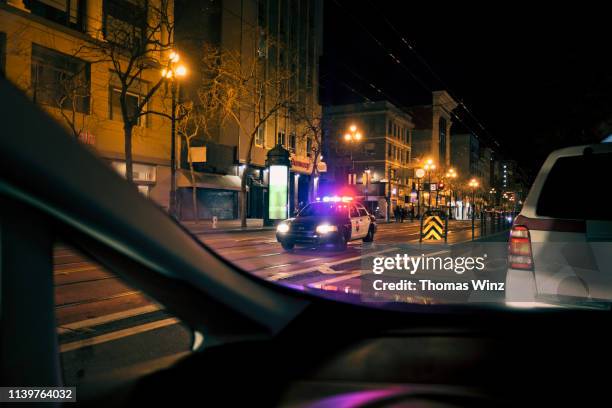 police car with emergency lights on in downtown district - police car lights 個照片及圖片檔