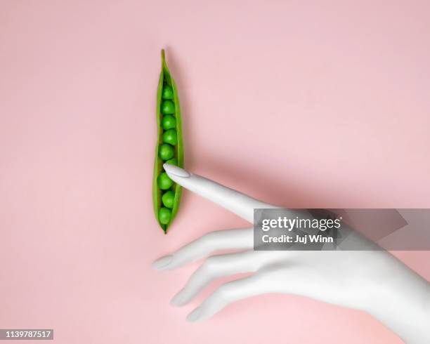 hand touching peas in a pod - 性的行動 ストックフォトと画像