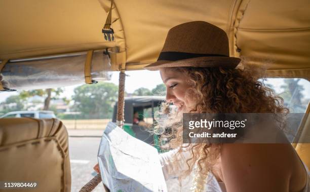 glückliche frau, die mit dem auto in colombo, sri lanka, mit einer karte unterwegs ist - daily life in colombo stock-fotos und bilder