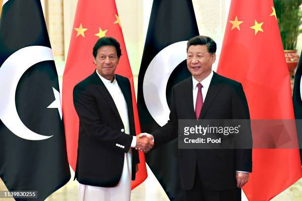 China's President Xi Jinping, right, shakes hands with Pakistan's Prime Minister Imran Khan before a meeting at the Great Hall of the People on April...