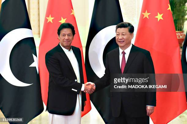 China's President Xi Jinping shakes hands with Pakistan's Prime Minister Imran Khan before their meeting at the Great Hall of the People in Beijing...