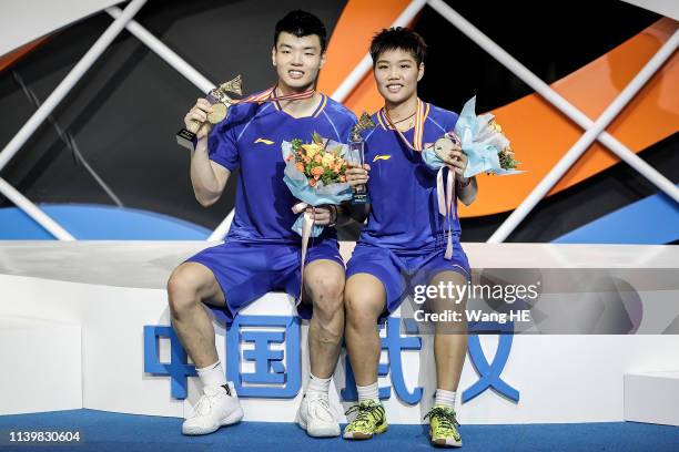 Wang Yulyu and Huang Dongping of China pose with gold medals on the podium after winning the mixed doubles final match against He Jiting and Duyue at...