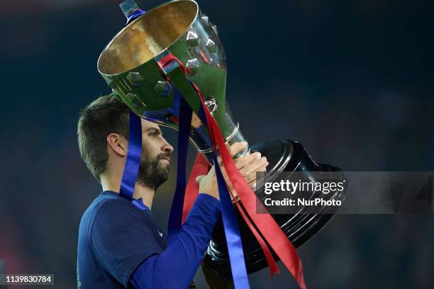 Gerard Pique lifts the league champion trophy after Barcelona won their 26th league title at the end of the Spanish League football match between...