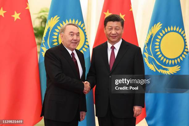 China's President Xi Jinping, right, shakes hands with Kazakhstan's Former President Nursultan Nazarbayev before a meeting at the Great Hall of the...