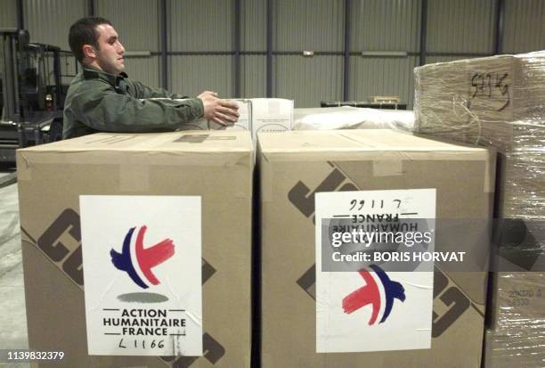 Un militaire français empile des cartons contenant de l'aide humanitaire à destination de Skopje , le 02 avril 1999 sur la base militaire aérienne...