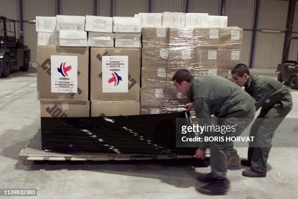 Des militaires français empilent des cartons contenant de l'aide humanitaire à destination de Skopje , le 02 avril 1999 sur la base militaire...