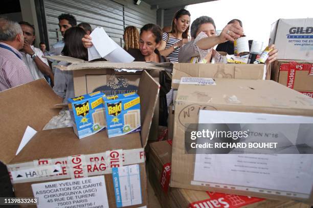 Des personnes ouvrent des cartons contenant des répulsifs le 21 avril 2006 à l'aéroport Roland Garros sur l'Ile-de-la-Réunion où sévit une épidémie...