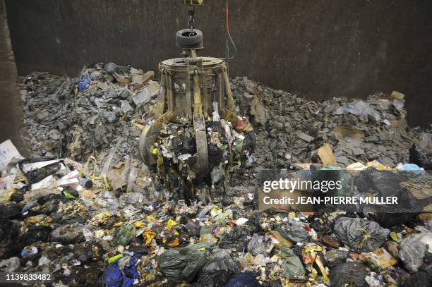 Un grappin piloté depuis une salle de contrôle s'empare de déchets ménagers, le 1er octobre 2008 au centre de traitement des déchets recyclables de...