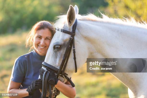 woman hugging her horse - racehorse owner stock pictures, royalty-free photos & images