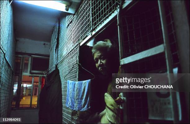 Cage people, or the issue of precariousness in Hong Kong city, Hong Kong in March, 2006-Man in his cage house at night in the area of Taikok Tsui in...