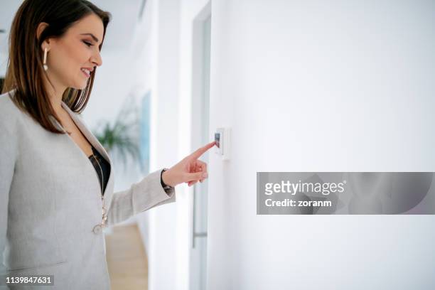 geschäftsfrau mit finger am lichtschalter - lichtschalter stock-fotos und bilder