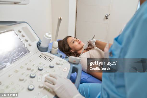 junge krankenschwester scannen patientenkehle - cervical screening stock-fotos und bilder