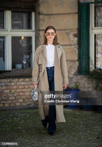 Swantje Sömmer is seen wearing trench coat DAY, Calvin Klein jeans, Dior bag, black mules Dorateymur, Miu Miu sunglasses on April 01, 2019 in Berlin,...