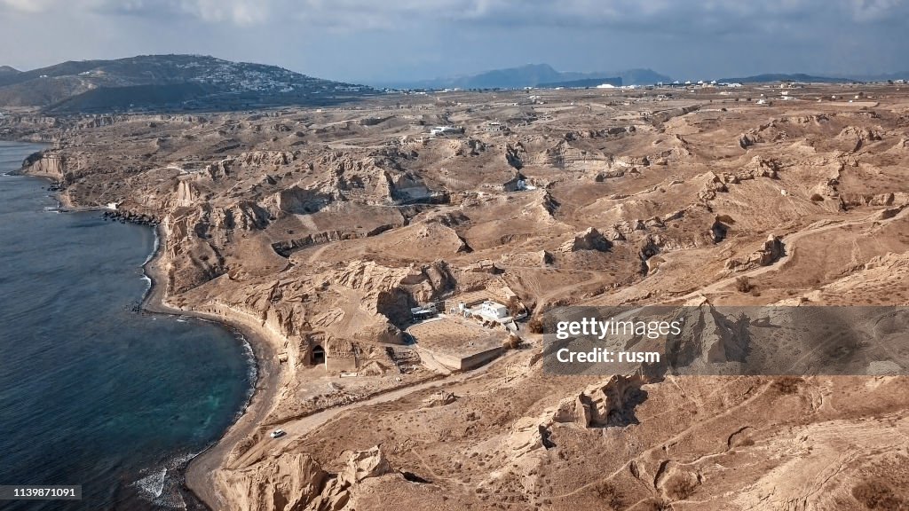 Flyg Panorama över karga lanscape och sand klippor på Vlihada Beach på Santorini Island, Grekland