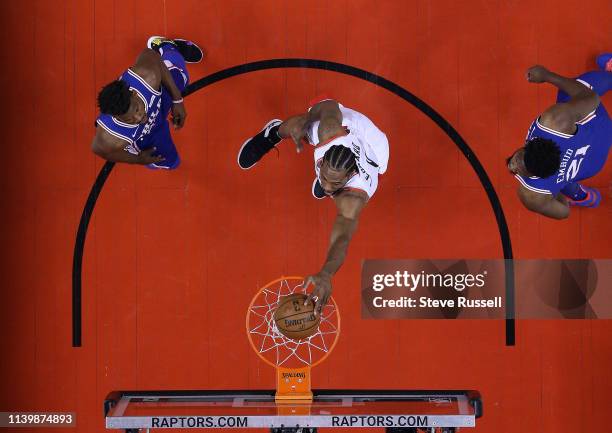 Toronto Raptors forward Kawhi Leonard dunks as Philadelphia 76ers guard Jimmy Butler and Philadelphia 76ers center Joel Embiid watch as the Toronto...