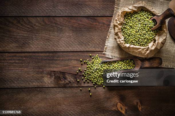 rustic paper bag and wooden serving scoop full of mung beans - mung bean stock pictures, royalty-free photos & images