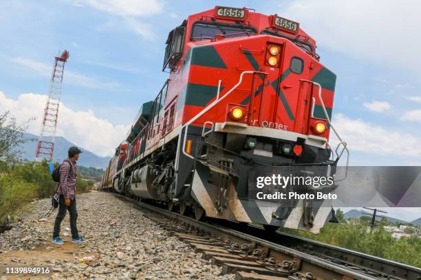 a young migrant prepares to board a train known as the beast along a railroad in mexico near the us border - united states border patrol imagens e fotografias de stock