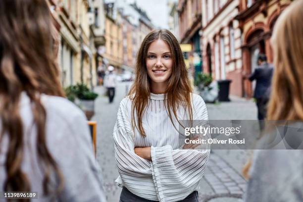 portrait of confident young woman with friends in the city - fu�ßgängerzone stock-fotos und bilder