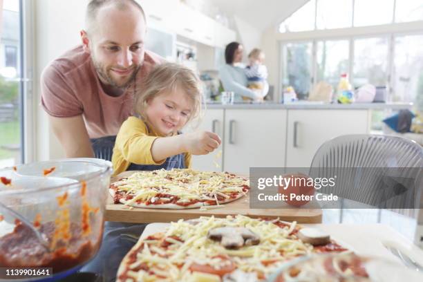 family making homemade pizza - cooking preparation stock pictures, royalty-free photos & images