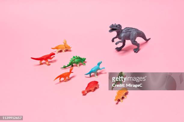 toy dinosaurs confliction - exclusion concept stock pictures, royalty-free photos & images
