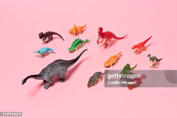 a crowd of toy dinosaurs - different animals together stock-fotos und bilder