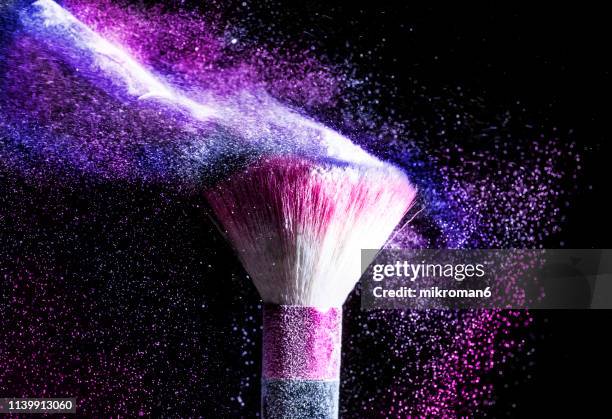 powder blowing from makeup brushes - industrie de la mode photos et images de collection