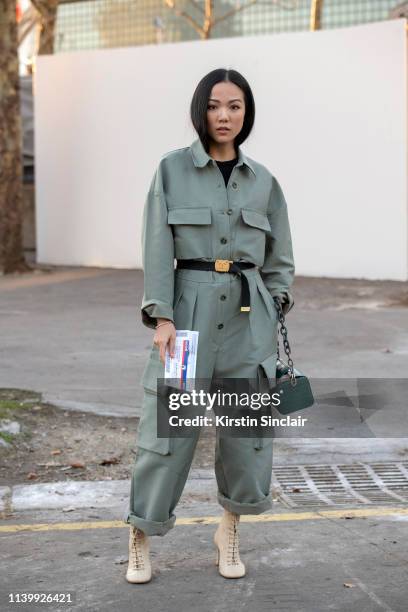 Digital Influencer Yoyo Cao wears Celine boots, The Volon bag, Frankie Shop boiler suit and Chanel belt and a on February 26, 2019 in Paris, France.