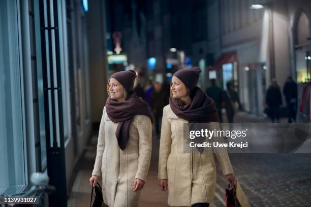 two young women shopping in pedestrian area - identical twin stock pictures, royalty-free photos & images