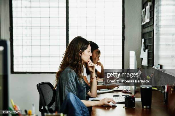 female business colleagues working at computers in design studio - design studio stock pictures, royalty-free photos & images