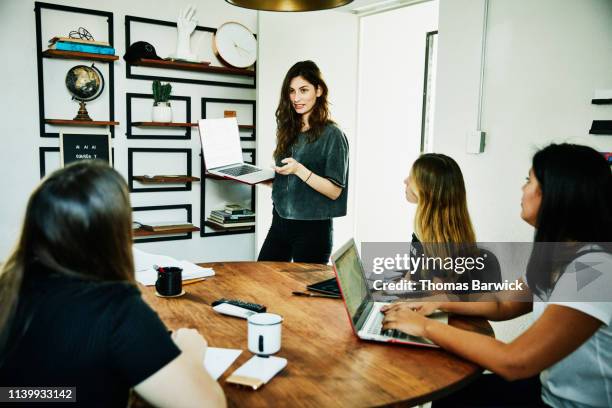 female graphic designer presenting project ideas to colleagues during meeting - trabalho de design imagens e fotografias de stock