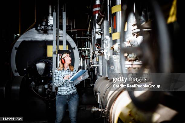 jonge vrouwelijke technicus is het controleren van verwarmingssysteem in ketel kamer - gasturbine stockfoto's en -beelden