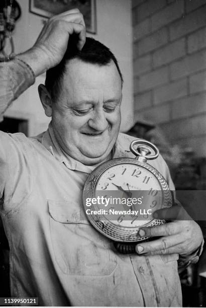 Charley Hohmann of St. James, New York scratches his head and holds a clock that he purchased in a novelty shop to illustrate his frustration with...