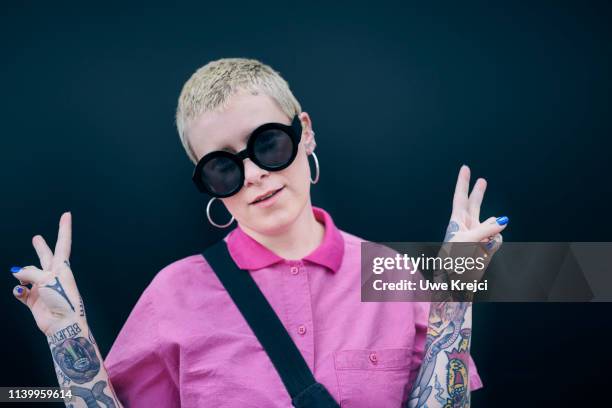 portrait of woman with tattoos against black background - earring stud stock pictures, royalty-free photos & images