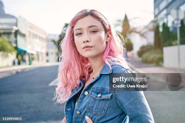 portrait of young woman on urban street - chaqueta tejana imágenes fotografías e imágenes de stock