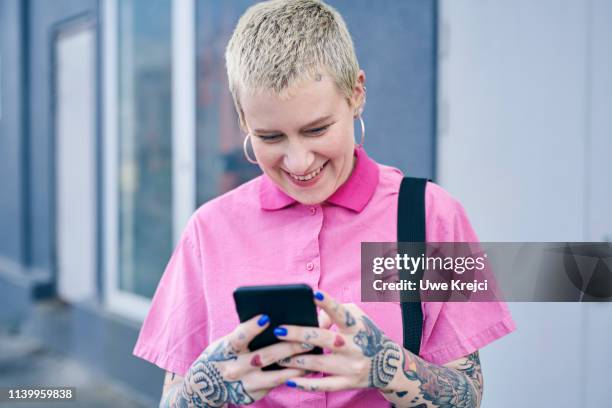 young woman texting on street - piercing stock pictures, royalty-free photos & images