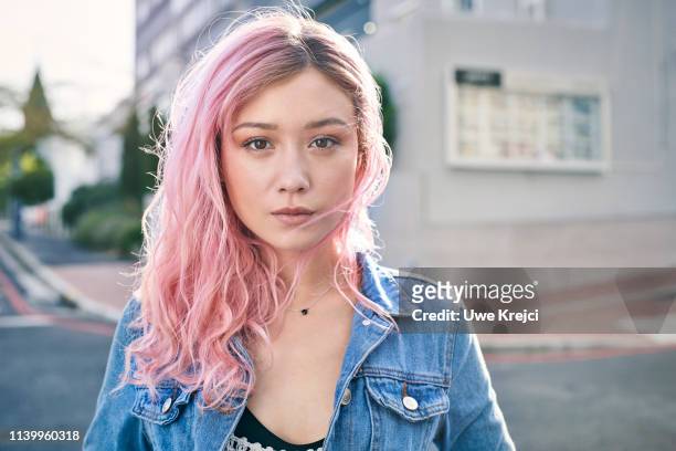 portrait of young woman on urban street - pink hair imagens e fotografias de stock