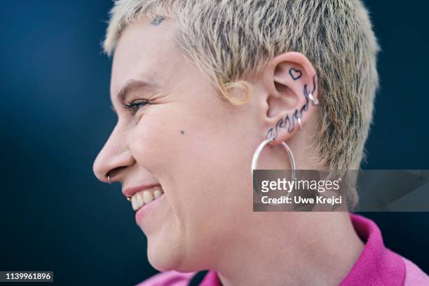 portrait of woman with tattoos against black background - earring closeup stock pictures, royalty-free photos & images