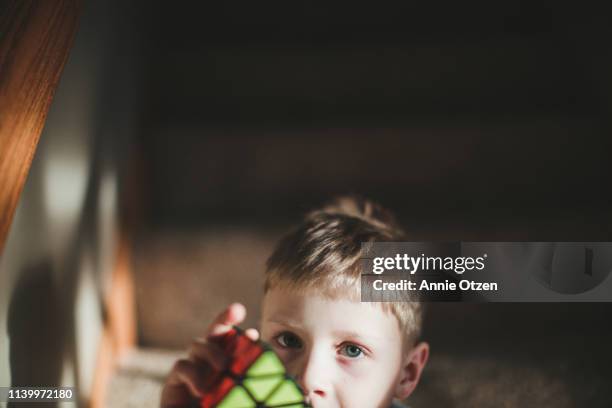 boy holding a puzzle cube - rubik's cube stockfoto's en -beelden