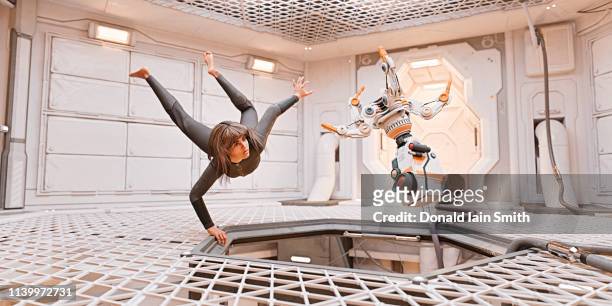 zero g: woman and robot floating adrift inside spaceship - gravitational field stock pictures, royalty-free photos & images