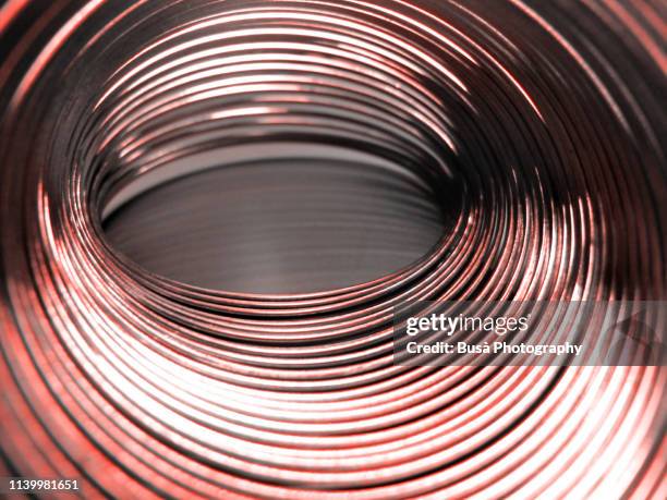 helical coil spring close-up (color manipulation with living coral pantone, color of the year 2019) - cable-de-acero fotografías e imágenes de stock