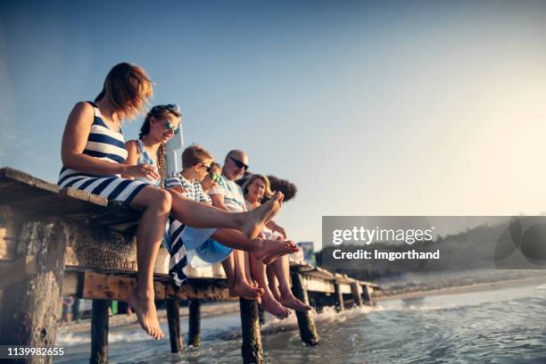 famille multi-génération appréciant des vacances d’été - ponton photos et images de collection