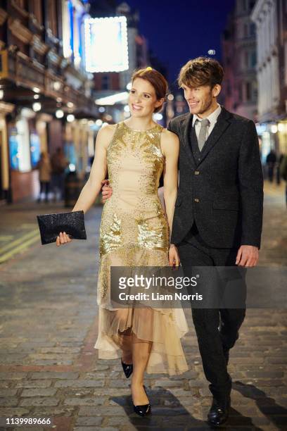 couple walking on street at night, london, uk - vestito da sera femminile foto e immagini stock