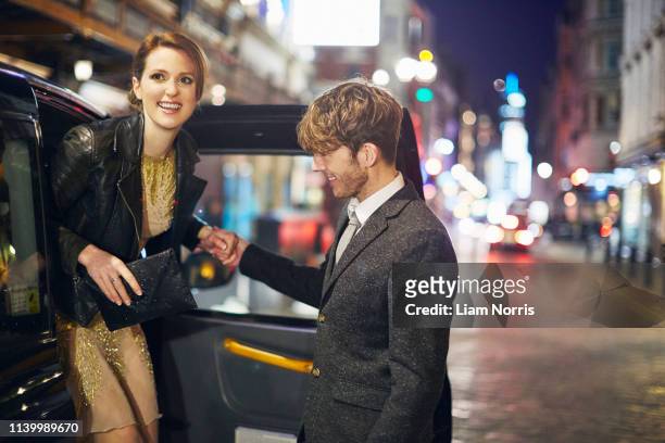 young woman exiting taxi cab, london, england - etiquette stock-fotos und bilder