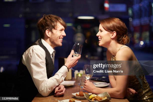 couple laughing in restaurant - mesa para dos fotografías e imágenes de stock