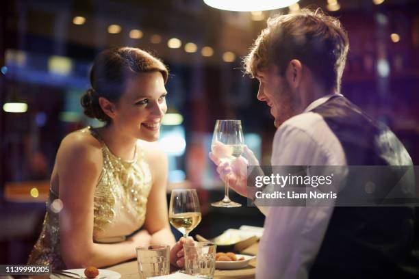 couple with wine glasses in restaurant - cena romantica foto e immagini stock