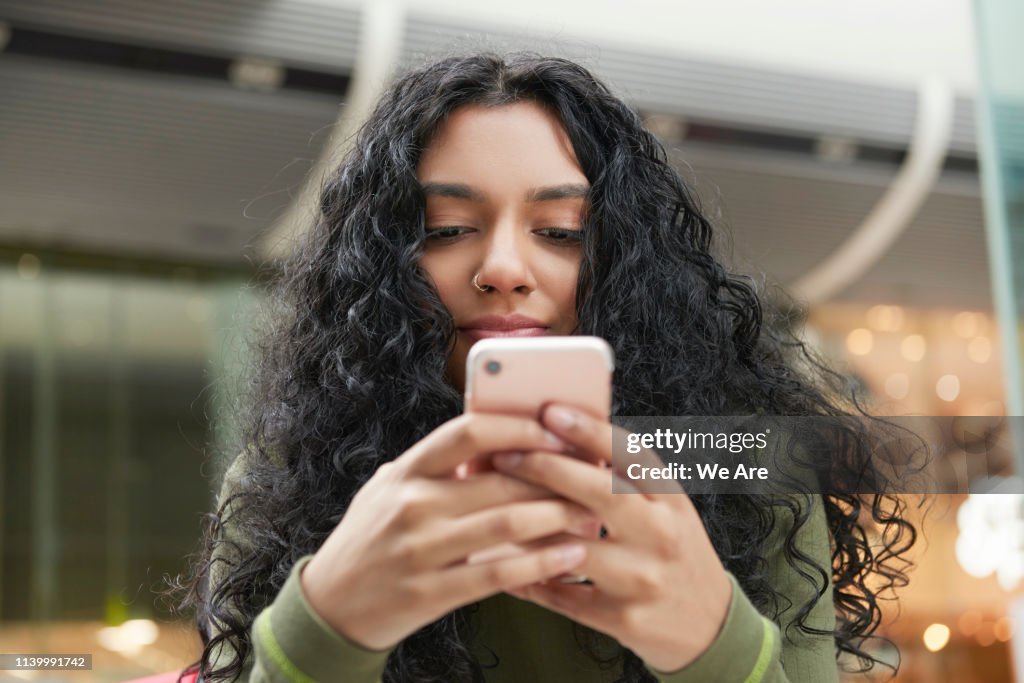 Young woman texting on smartphone