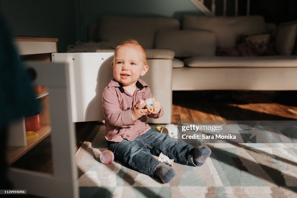 Baby On Rug Baby Boy Sitting Playing On Living Room Rug High-Res Stock Photo ...