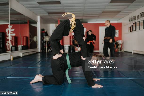 coach and students practising martial arts in studio - self defence stock-fotos und bilder