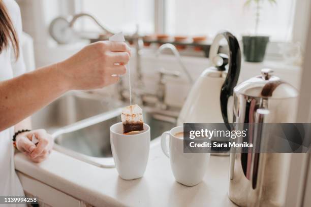 woman making tea in kitchen - making tea stock pictures, royalty-free photos & images